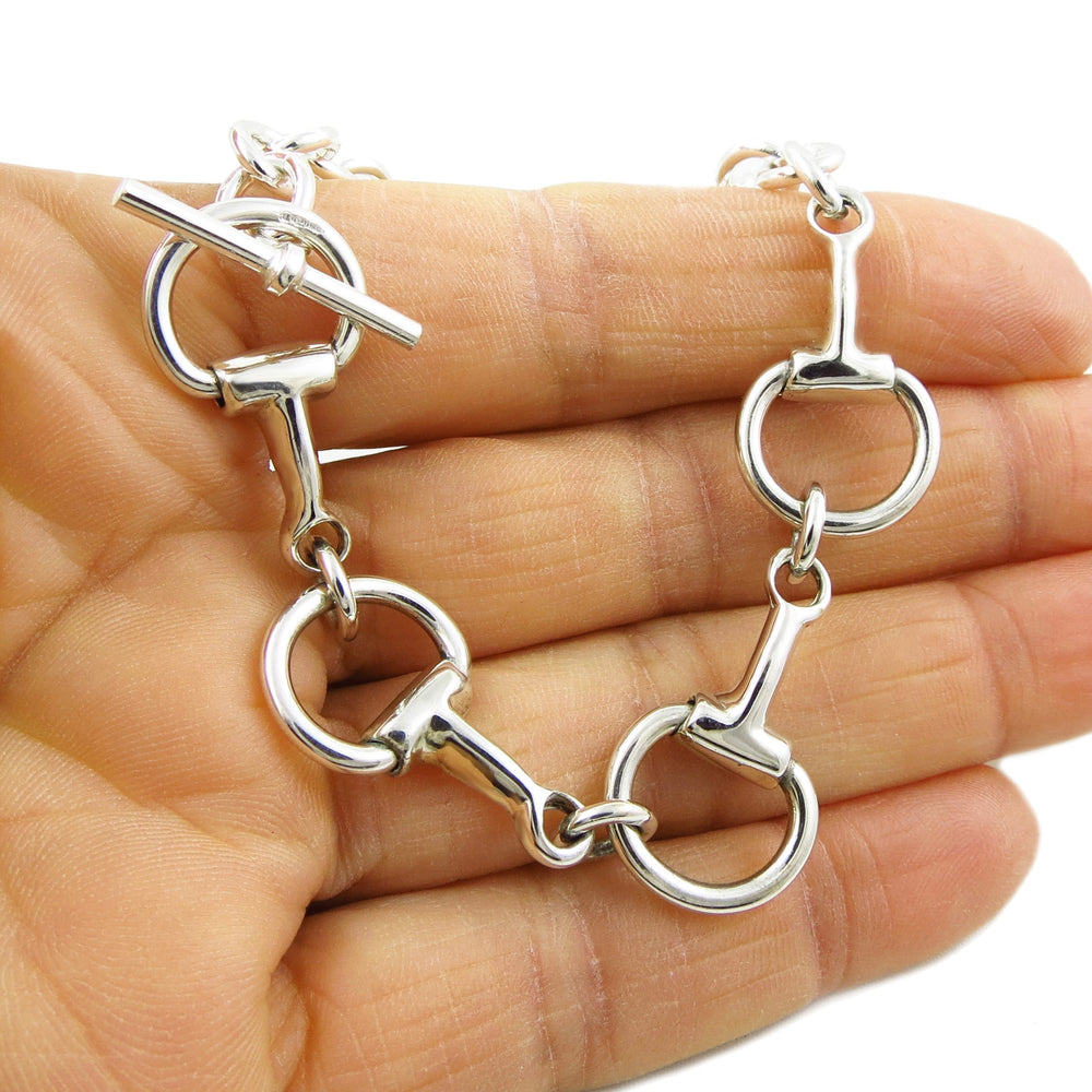 Solid 925 ssterling silver horse snaffle bridle bit bracelet on a hand against a white background