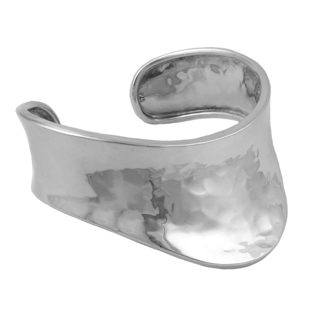 A wide hallmarked sculpted sterling 925 silver cuff style bracelet with a hand hammered finish on a white background. 