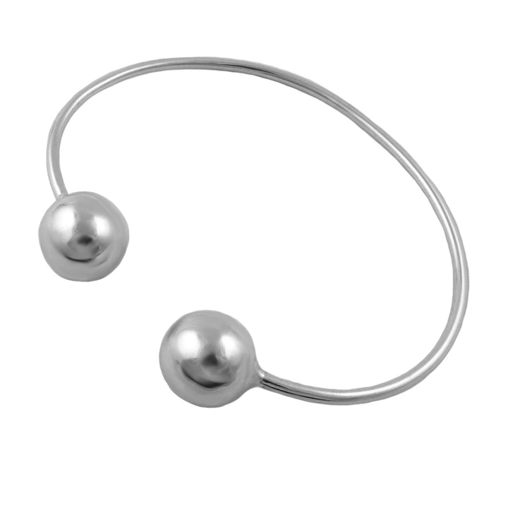 A minimalist UK hallmarked sterling 925 silver open cuff bracelet featuring two polished spherical bead accents on the ends, shown against a solid white background.
