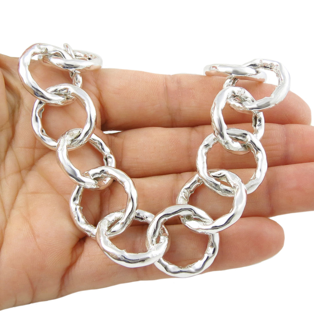 Chunky 925 silver chain bracelet held in a hand against a white background