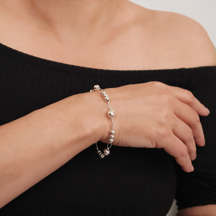 UK sterling 925 silver beaded and chain link bracelet on a woman's wrist against a neutral background