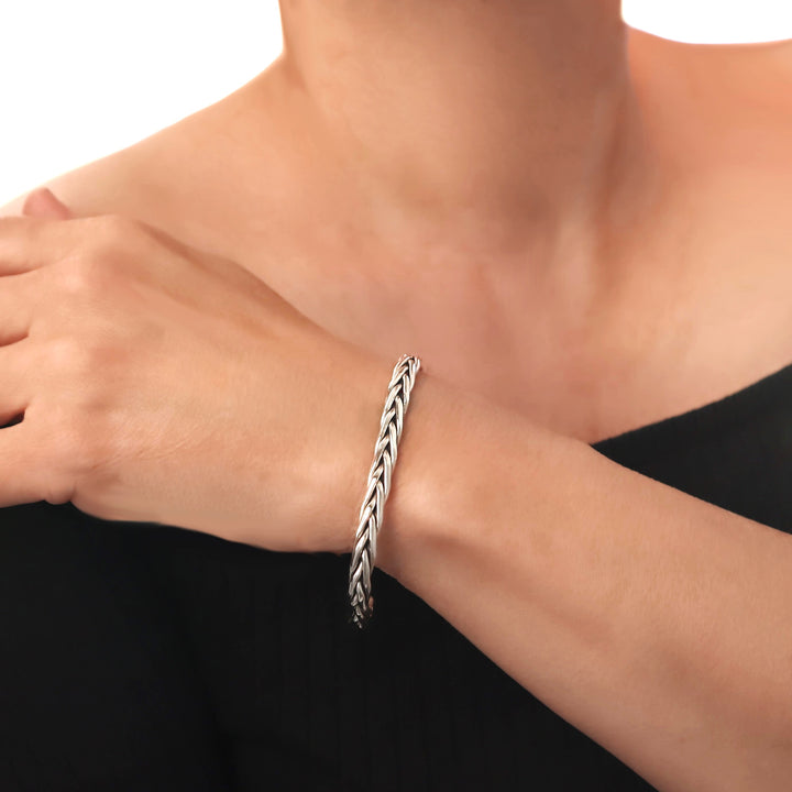 925 sterling silver braided woven bracelet on a woman's wrist with a blurred background