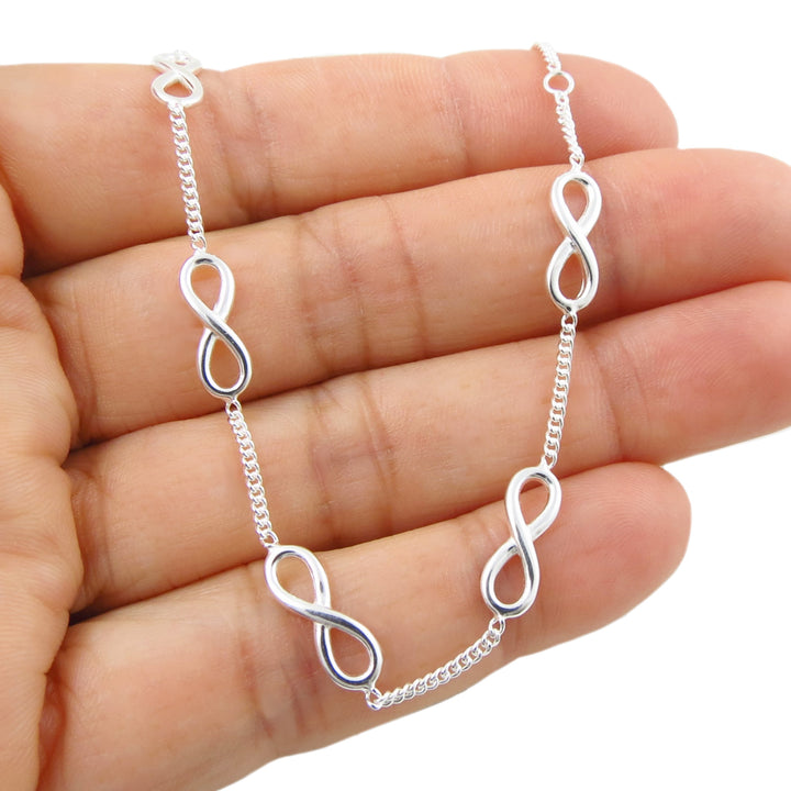 925 Silver infinity chain link bracelet on a hand with a white background