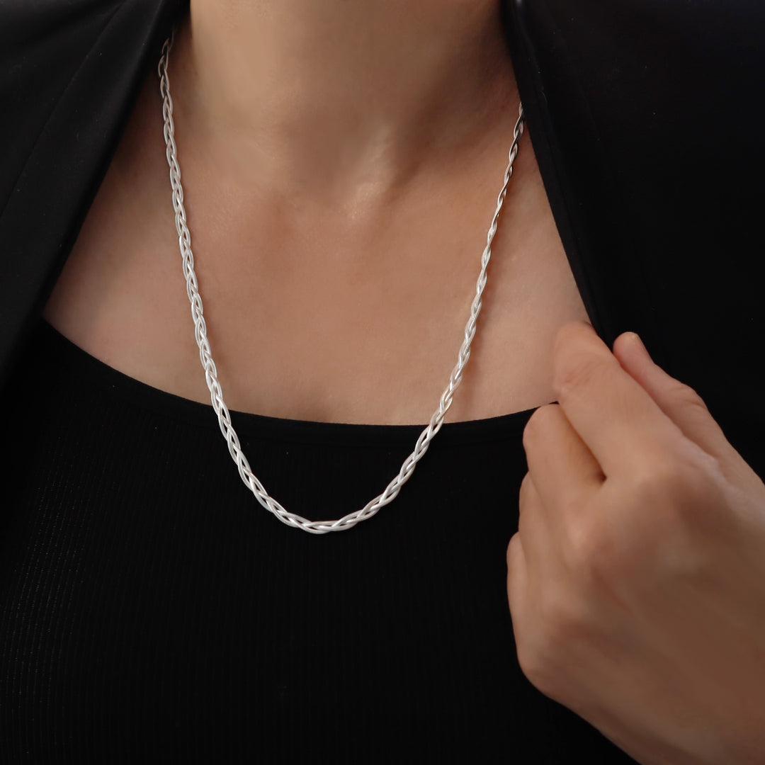 Woven sterling 925 Silver triple snake chain necklace being adjusted on a person wearing a black top.