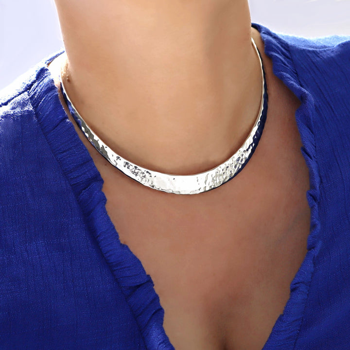 Hammered silver choker necklace worn by a person with a blue garment