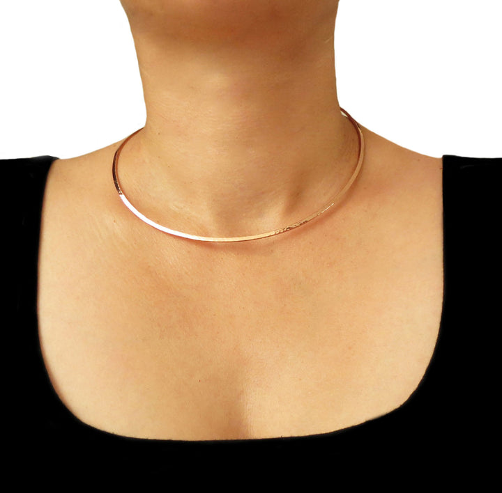 Hammered copper choker necklace worn by a woman in a black top