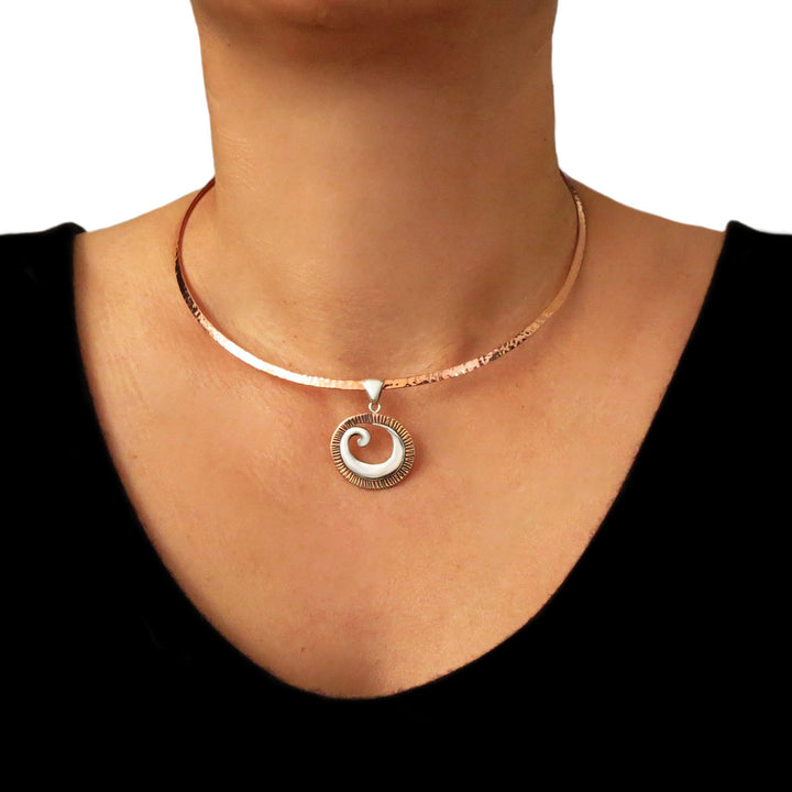 Hammered solid copper choker necklace with a spiral pendant worn by a woman on a white background