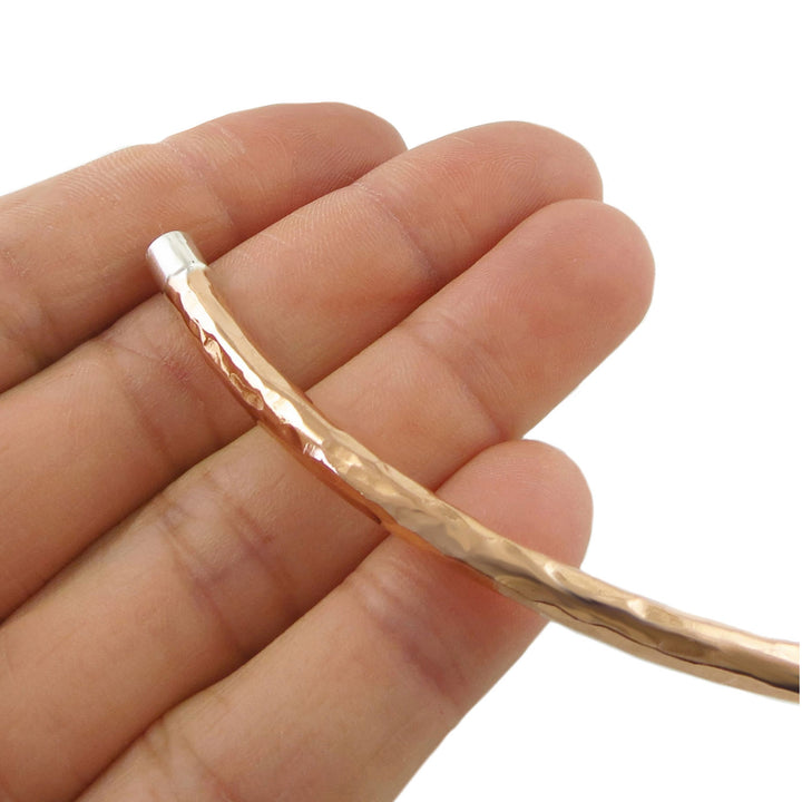 Women's hammered copper choker necklace with 925 silver accents held in a person's hand on a white background