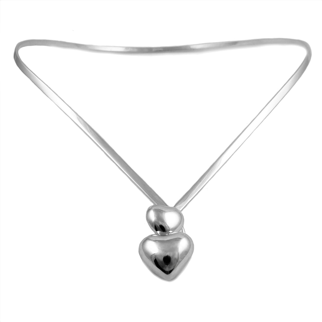 A polished sterling 925 silver choker necklace torque featuring a minimalist design with a thin band and heart shaped accents at the front. 