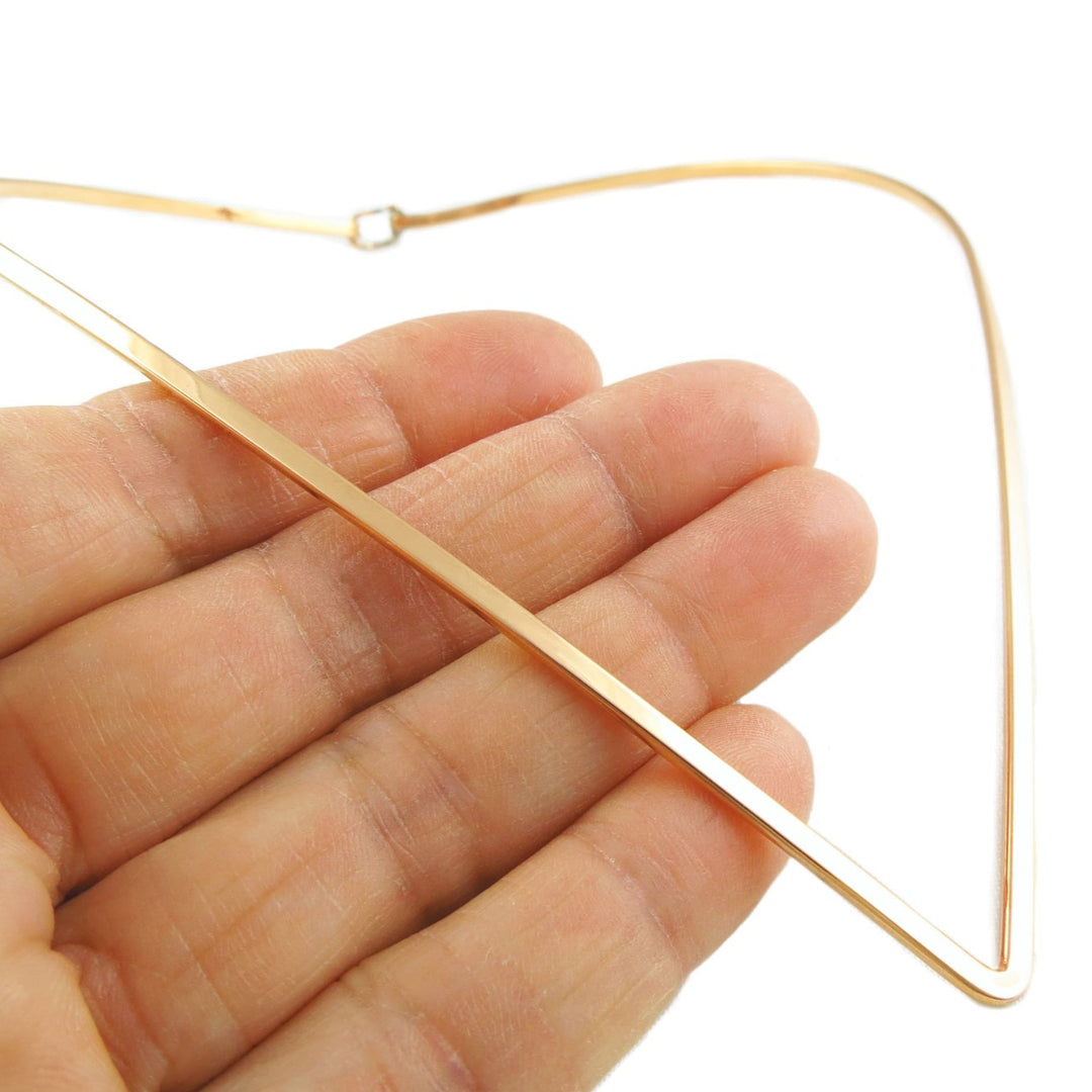 V-neck solid copper ladies choker necklace being held between fingers on a white background