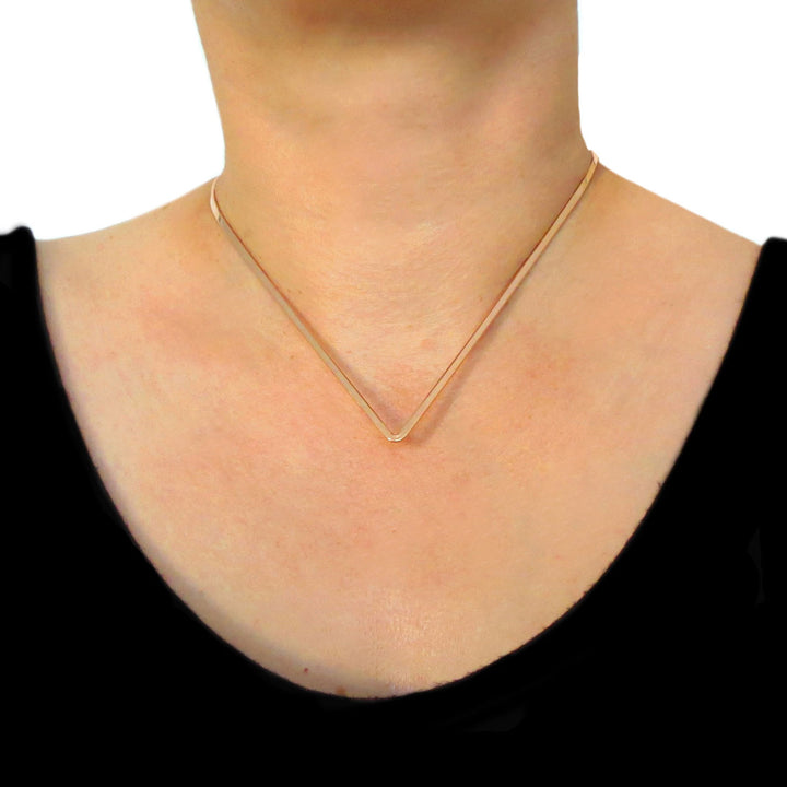 Fitted copper choker necklace worn by a woman in a black top