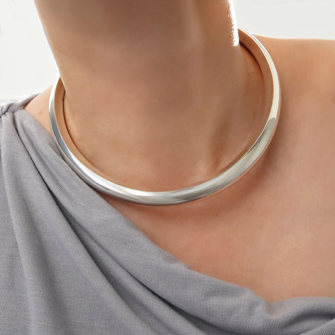 Sterling 925 silver fitted choker necklace torc worn by a woman with a neutral background
