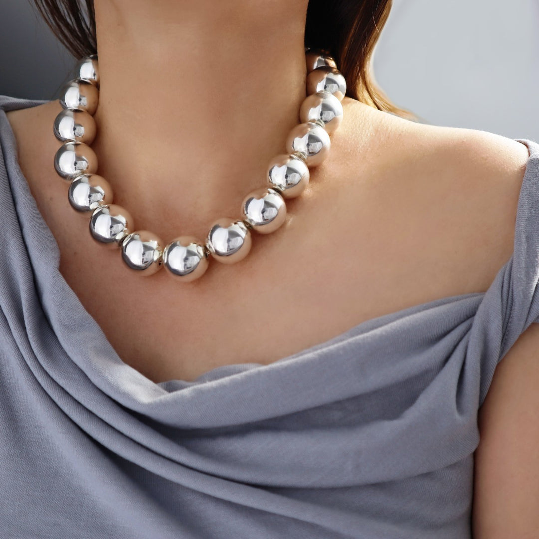 Woman wearing a chunky sterling silver ball bead necklace in evening wear