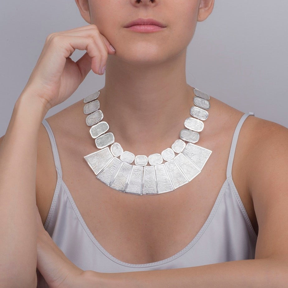 Woman wearing a bold Cleopatra-style sterling silver necklace, showcasing statement jewellery. 