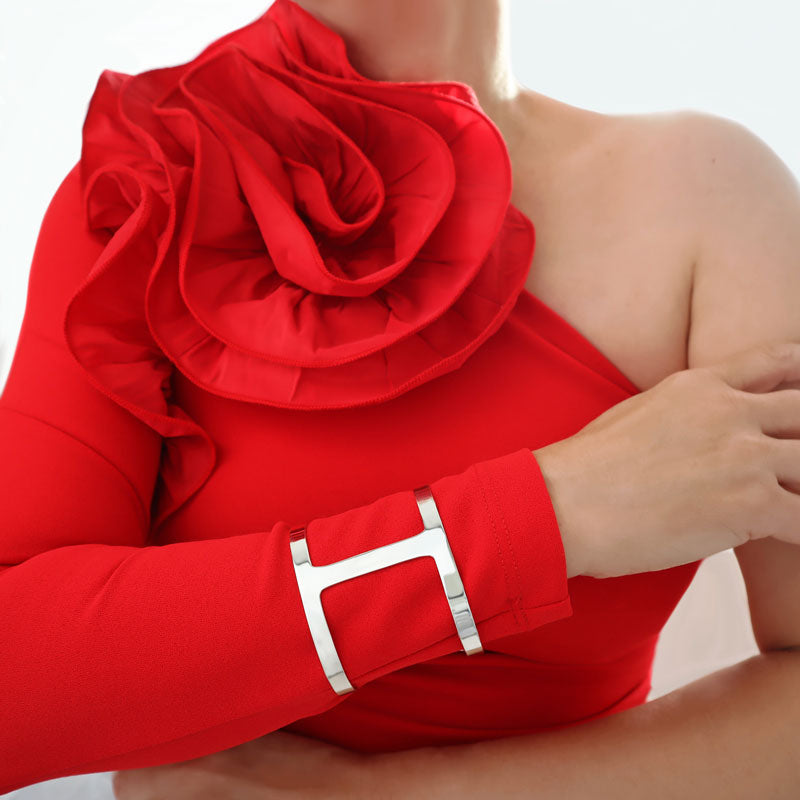 Woman in a red dress with a large frill wearing a wide handmade 925 UK sterling silver slave bracelet on one arm.
