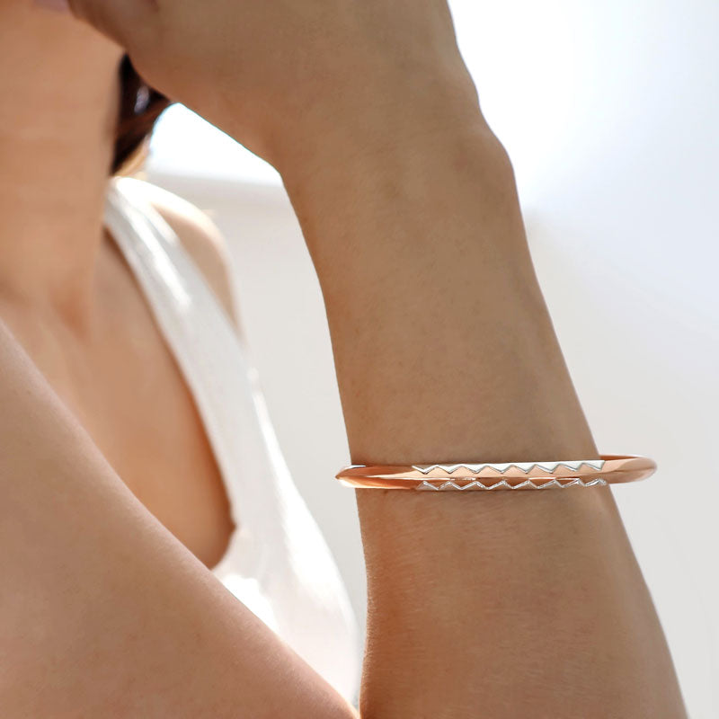 Woman wearing a two tone copper and 925 sterling silver modern bracelet cuff