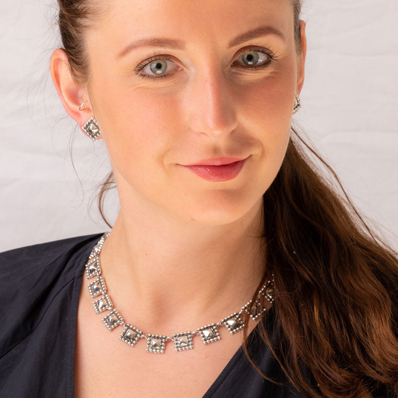 Woman wearing a Maria Belen Nilson square link Mexican handmade 925 sterling silver necklace and matching earrings