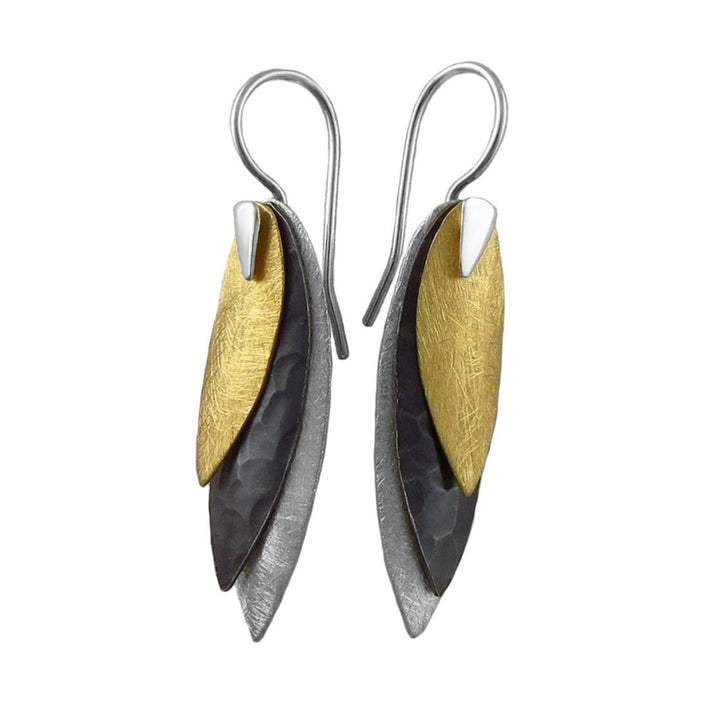 Pair of earrings with mixed metal gold and 925 silver leaf-like drops on a white background