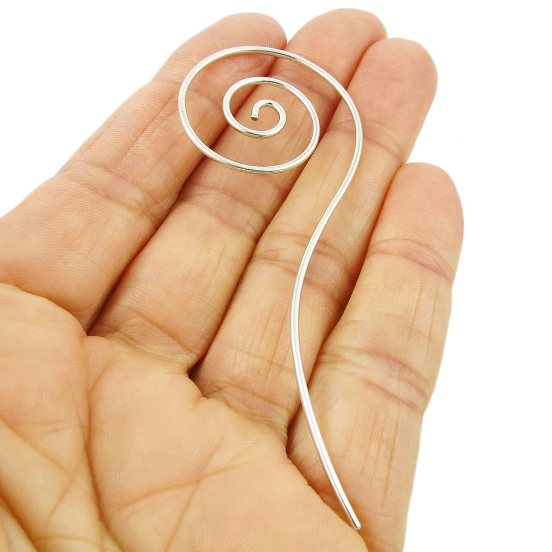 Long handmade jewellery 925 sterling silver spiral earrings with threaders held in a person's hand on a white background. 