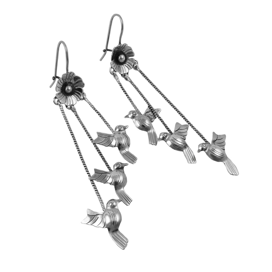 Long 925 sterling Mexican silver unique bird dangling earrings on a white background