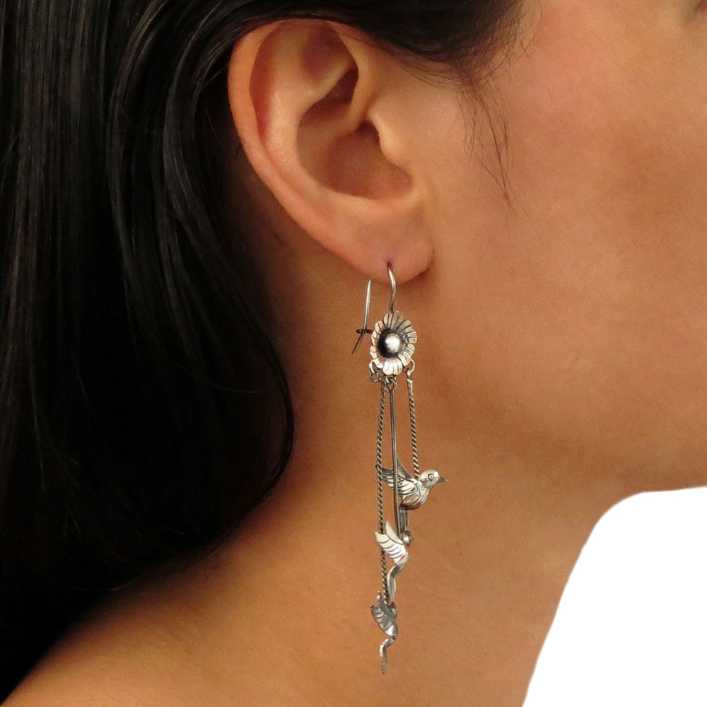 Taxco sterling 925 silver lovebird dove chandelier earring worn by a woman with dark hair.