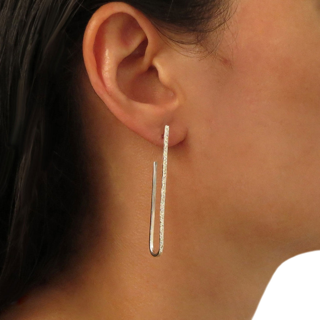 Long sterling 925 silver oval hoop earrings worn by a woman with dark hair