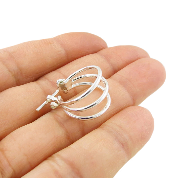 925 sterling silver triple circle earring with a unique hinged post held between fingers on a white background