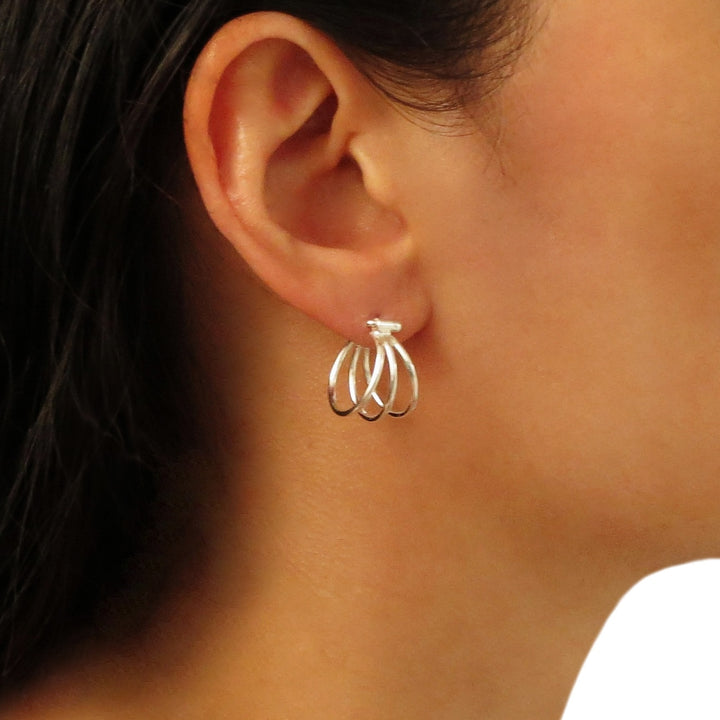 A woman with dark hair wearing a unique triple illusion hoop earring handmade from 925 silver