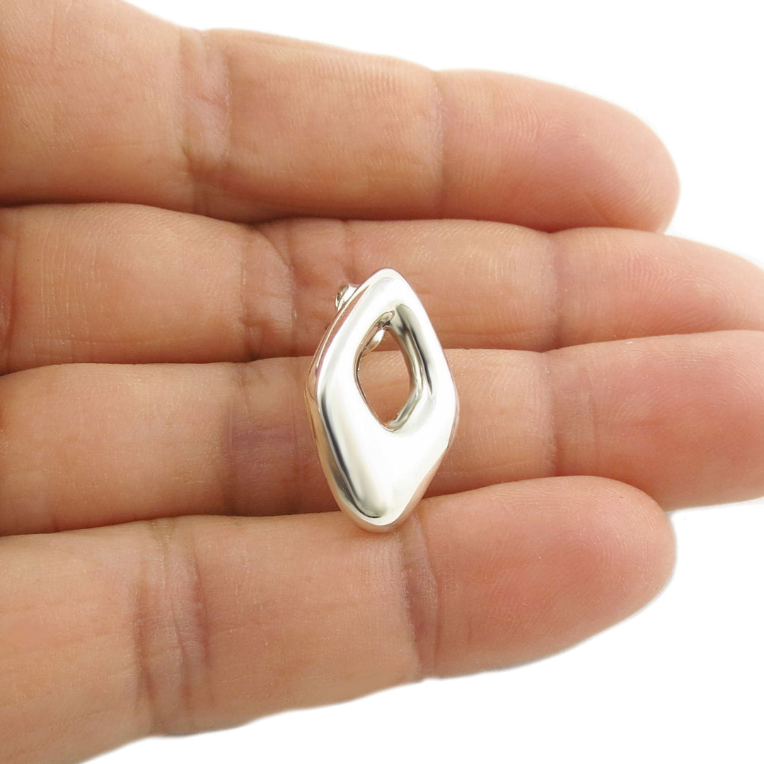 A large rhombus 925 sterling silver stud earring held in a woman's hand on a white background.  