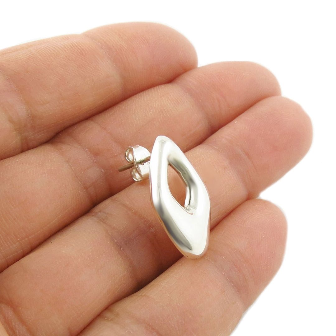 Puffed diamond-shaped silhouette 925 silver earring held in a woman's hand 