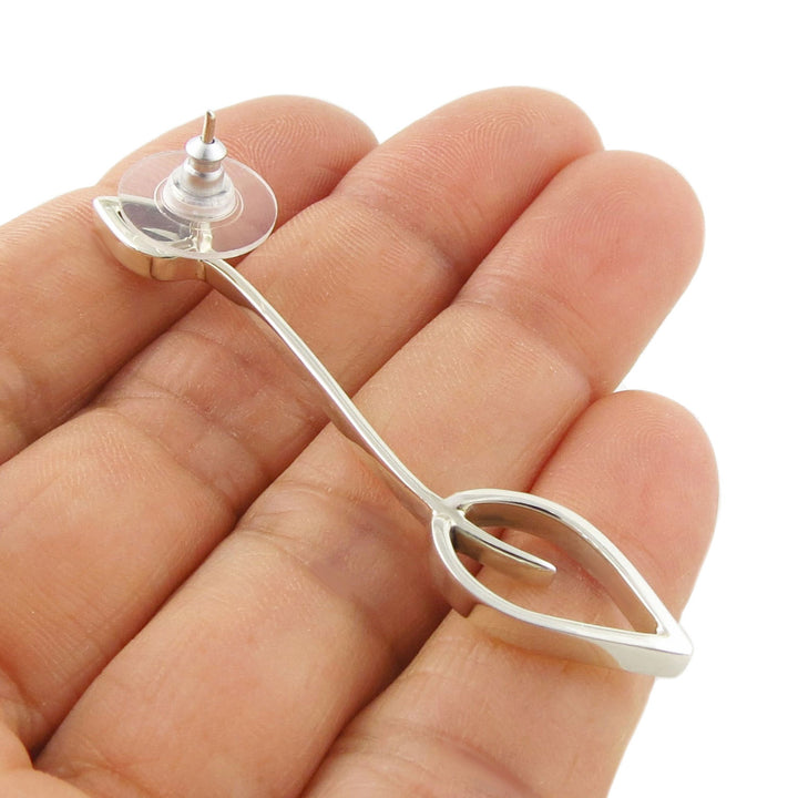 Sterling 925 Silver leaf shaped long drop earring held between a woman's fingers against a white background