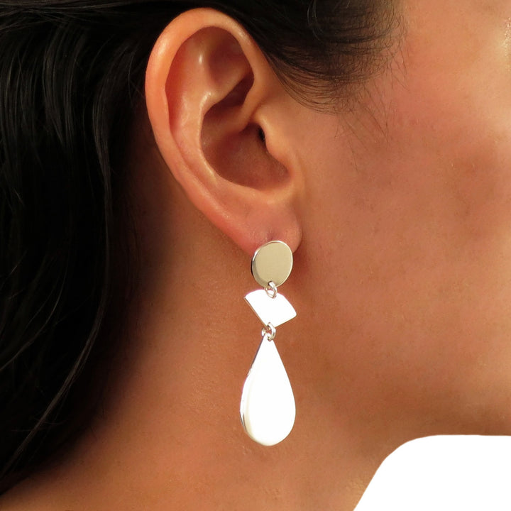 Close-up of a long earring worn by a woman with dark hair.