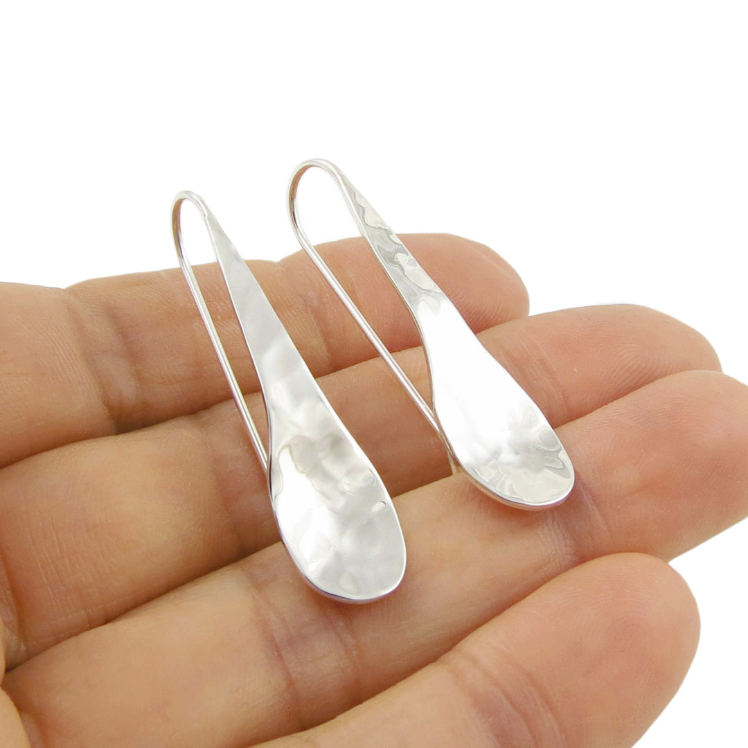 925 Silver teardrop earrings held in a hand against a white background