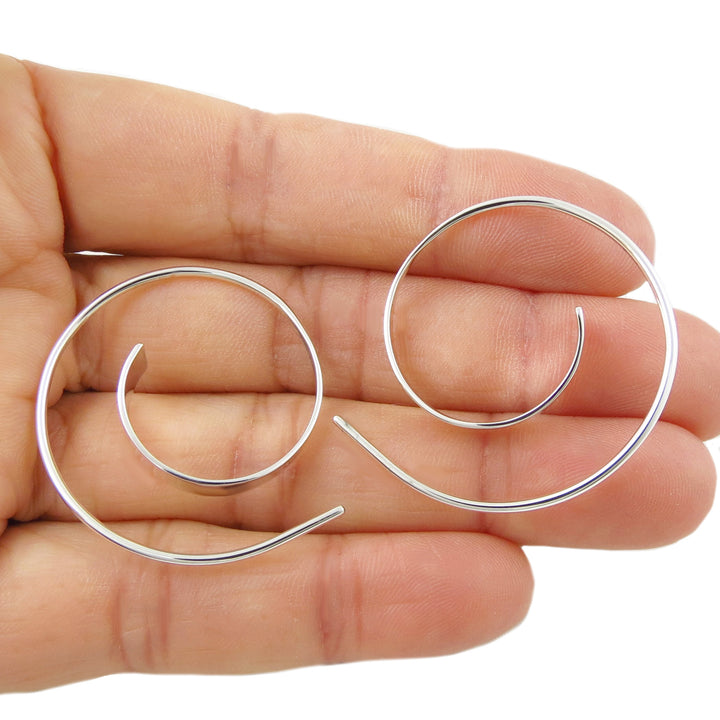 Handmade 925 sterling silver spiral threader earrings for women held between fingers on a white background