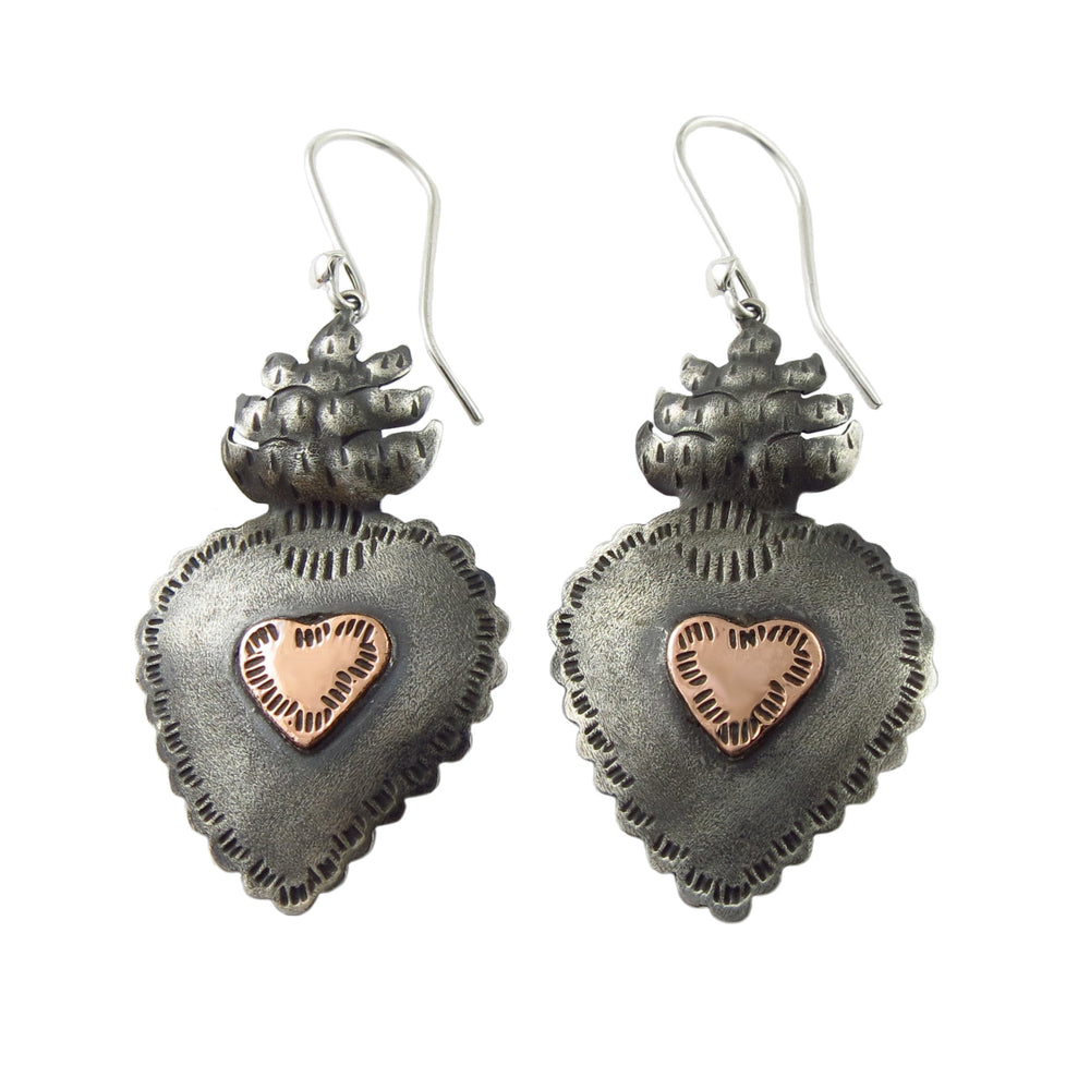 A pair of Mexican 925 sterling silver and copper sacred love heart earrings by Maria Belen Nilson with a flaming heart motif, suspended from silver hooks.