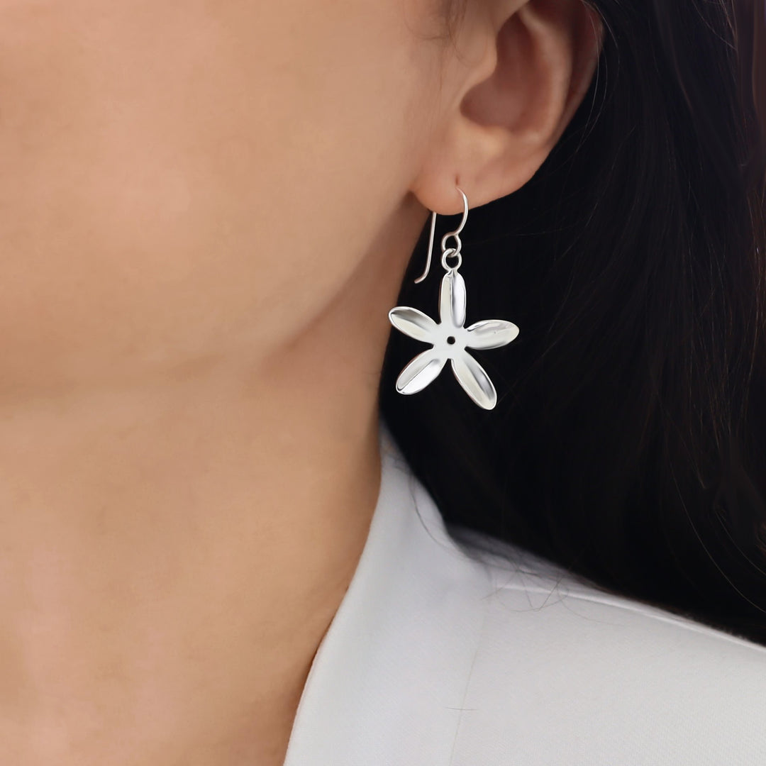 925 silver daisy earrings jewellery worn by a woman with dark hair