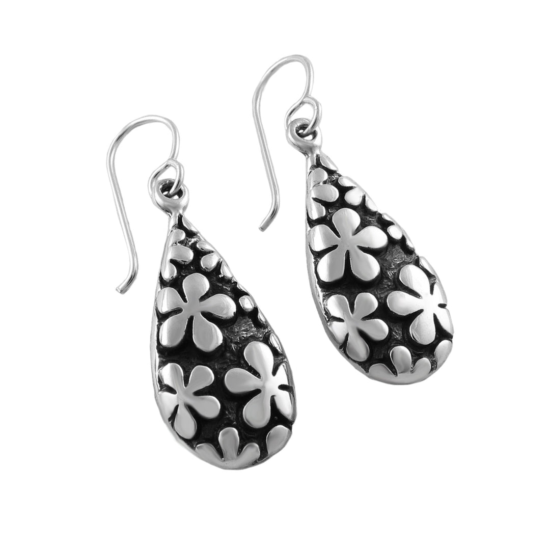 Large 925 sterling silver teardrop earrings for women with a polished daisy flower pattern on a blackened antiqued base. 