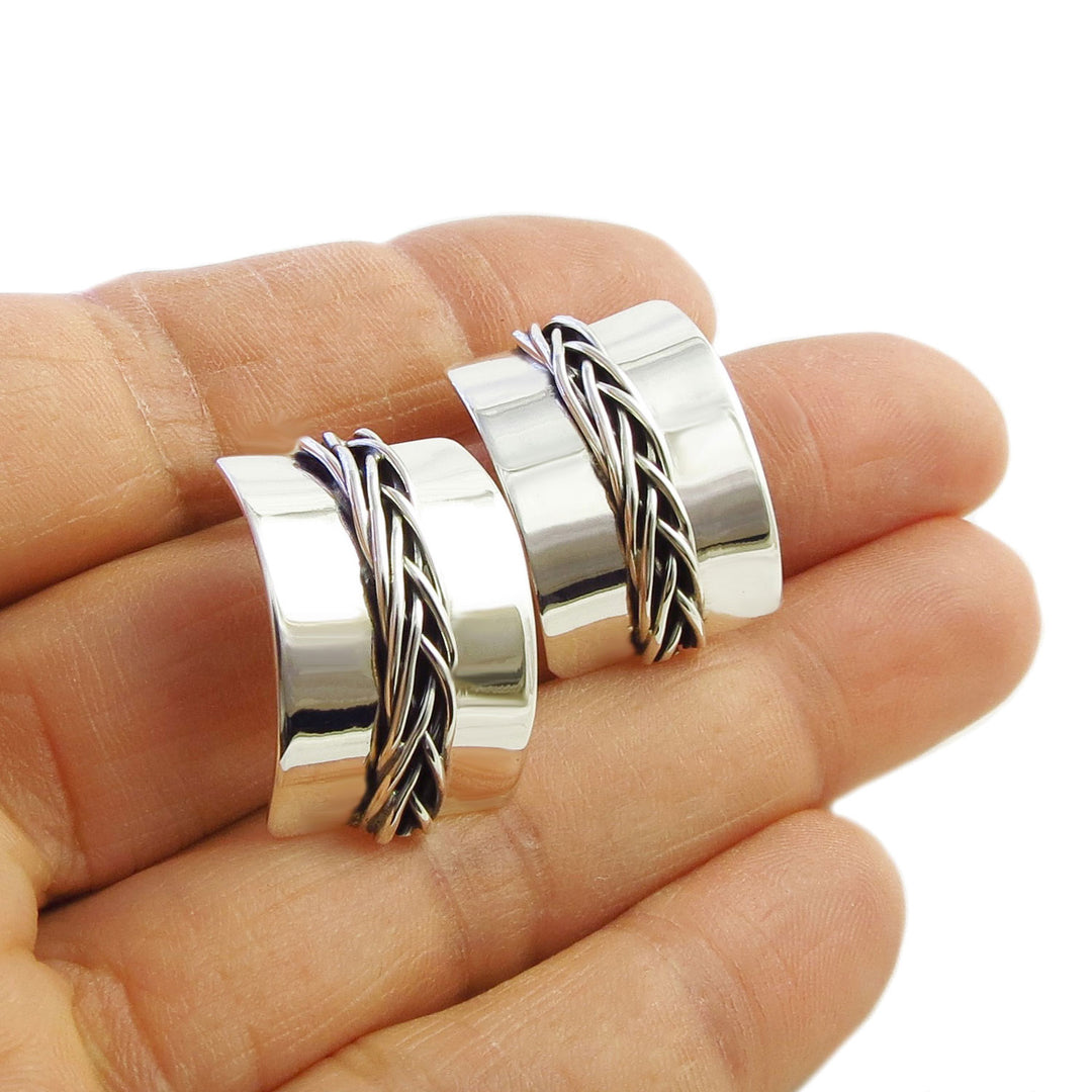 Sterling 925 silver rectangle curved drop earrings with a woven design down the middle held in a person's hand
