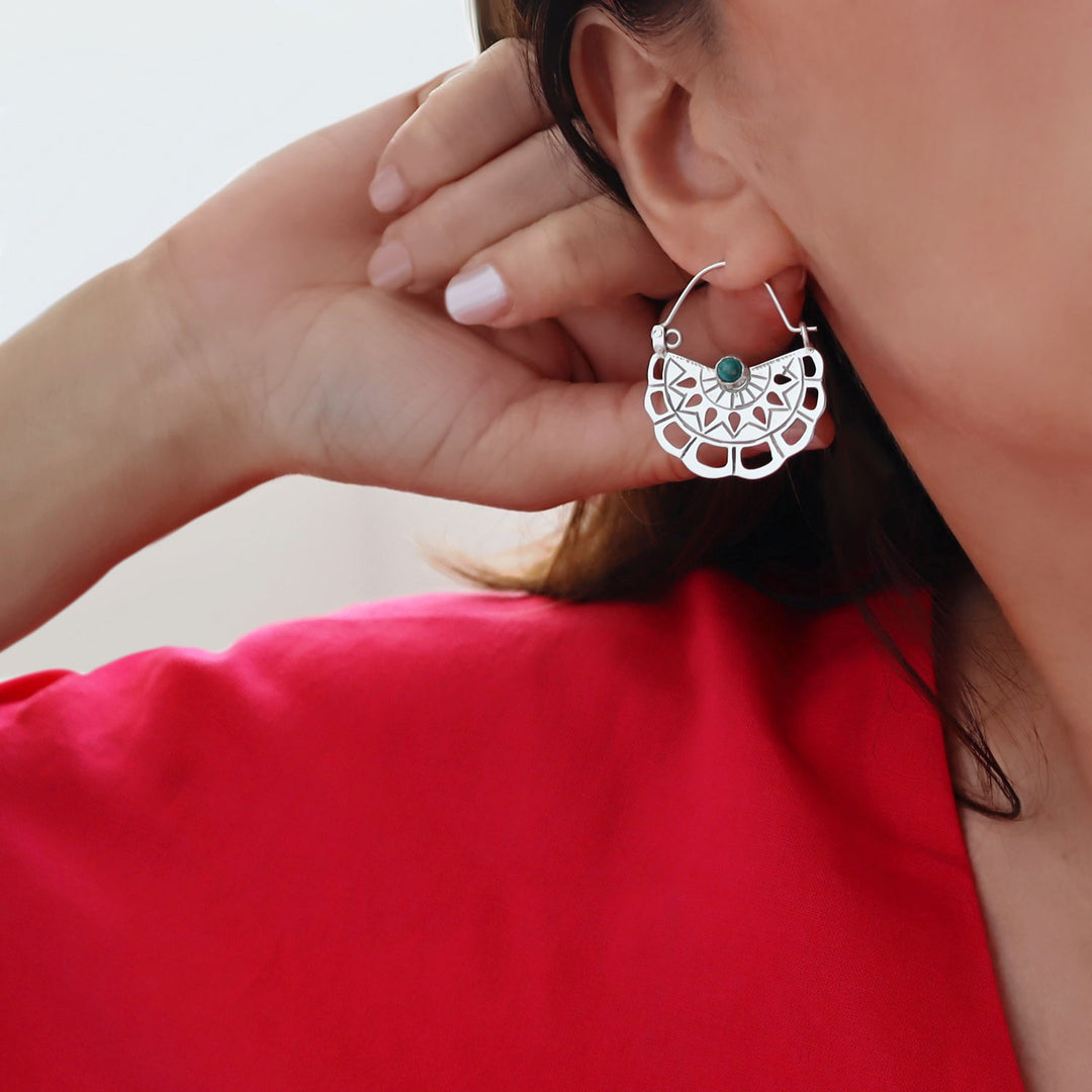 Sterlling 925 silver earrings with a turquoise gemstone worn by a lady with a red garment.