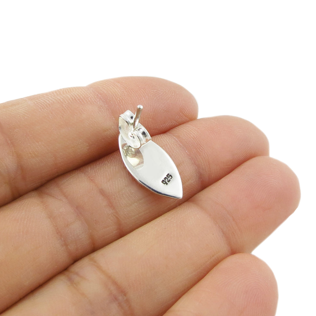 Revere of an curved stud earring in 925 silver revealing the 925 hallmark, hel in a person's hand. 