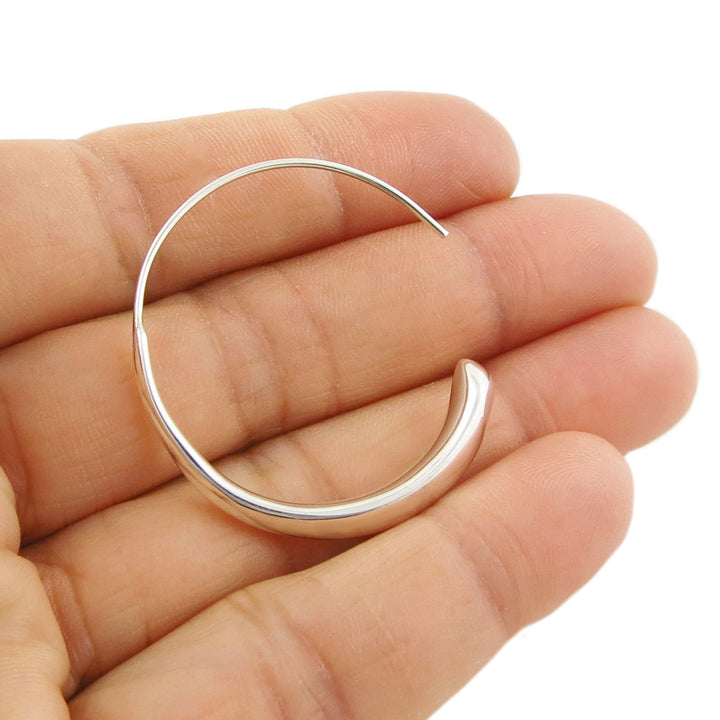 Sterling 925 silver circle threader hoop earring held between a woman's fingers on a white background