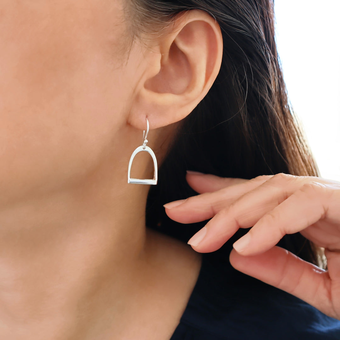 UK 925 sterling silver large equestrian design horse stirrup earrings worn by a woman with dark hair