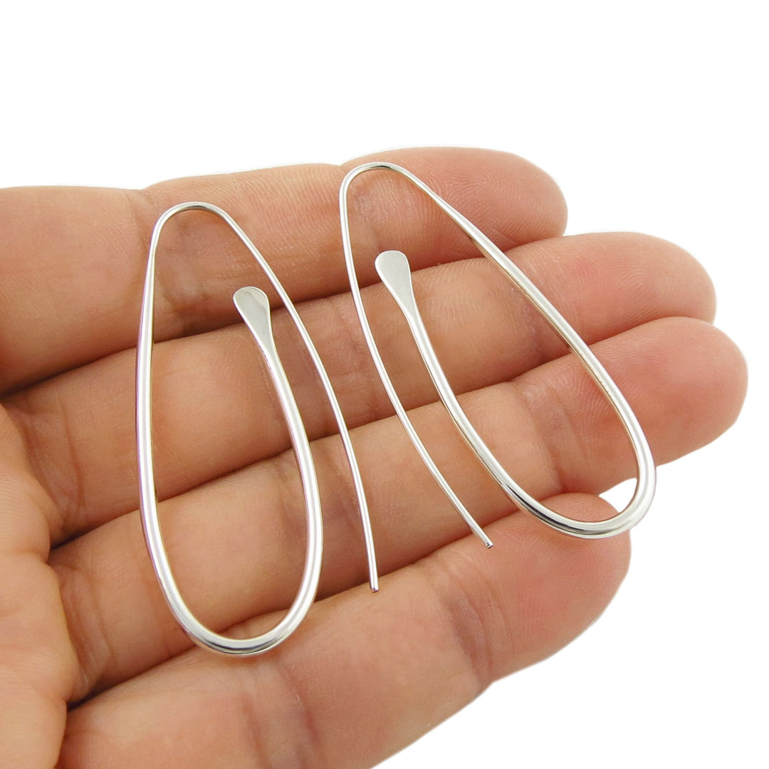 Long Sterling 925 silver spiral threader earring for women held in a hand on a white background