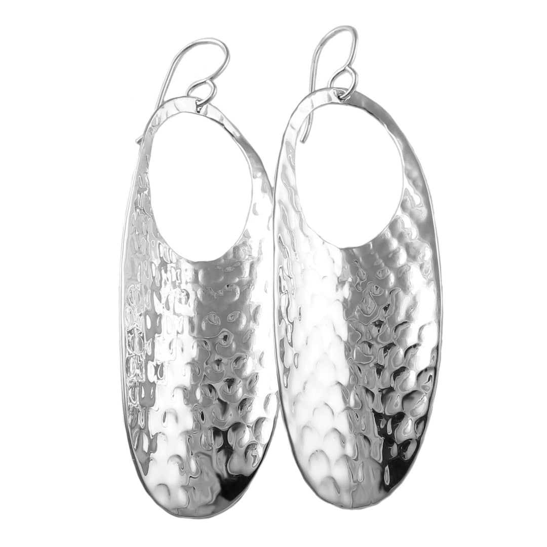 Pair of silver earrings with textured hammered design on a white background