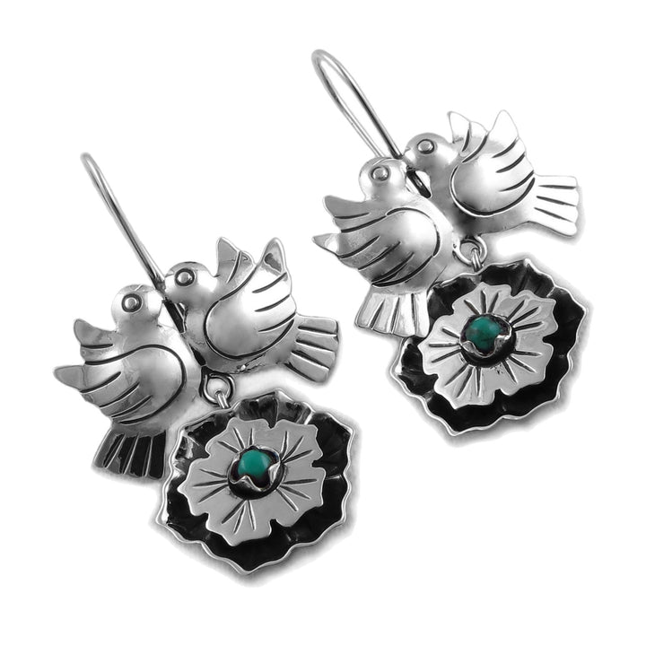 A pair of Mexican 925 sterling silver dangle earrings featuring a bird perched on a flower, with a small turquoise stone at the centre of the flower, shown on a plain white background.