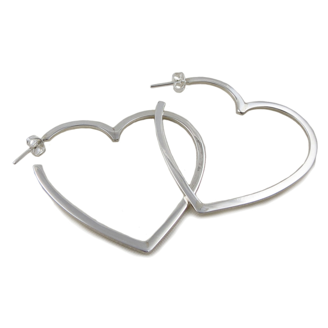 A pair of large 925 silver hoop earrings in the shape of love hearts on a white background 