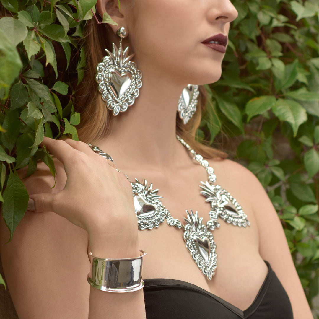 Woman wearing statement Mexican 925 sterling silver jewellery heart link set with leaves in the background