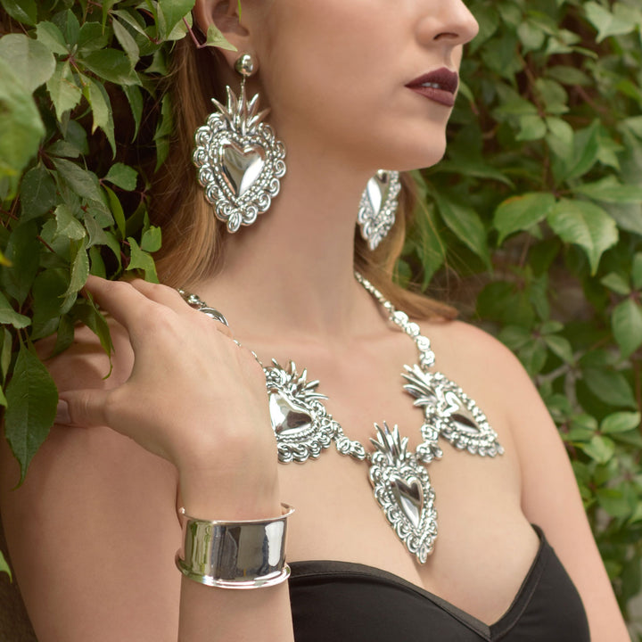 Woman wearing statement Mexican 925 sterling silver jewellery heart link set with leaves in the background
