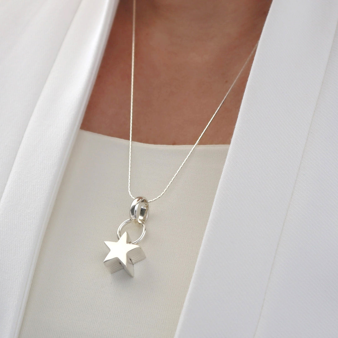 Silver necklace with star pendant on a white background