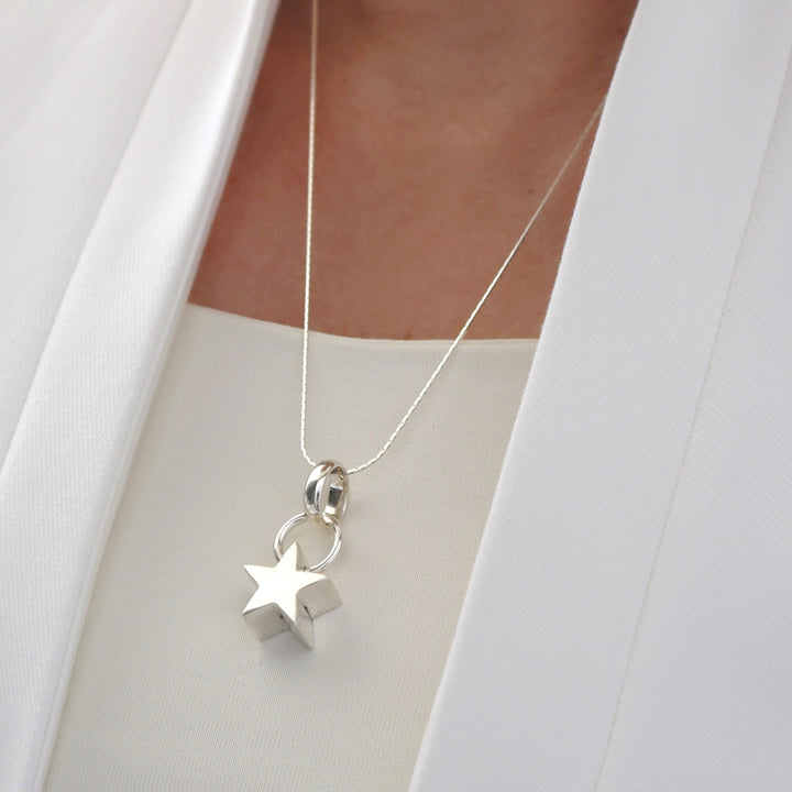Silver necklace with star pendant on a white background